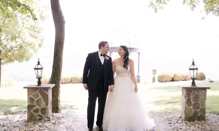 Groom and bride hold hands at Stroudsmoor ceremony site