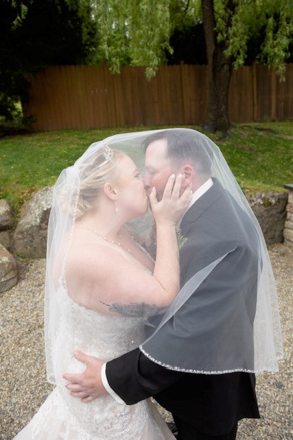 Bride and groom kiss beneath veil
