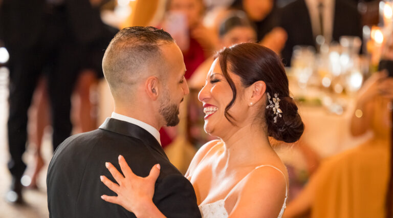 Bride and groom smile sharing first dance