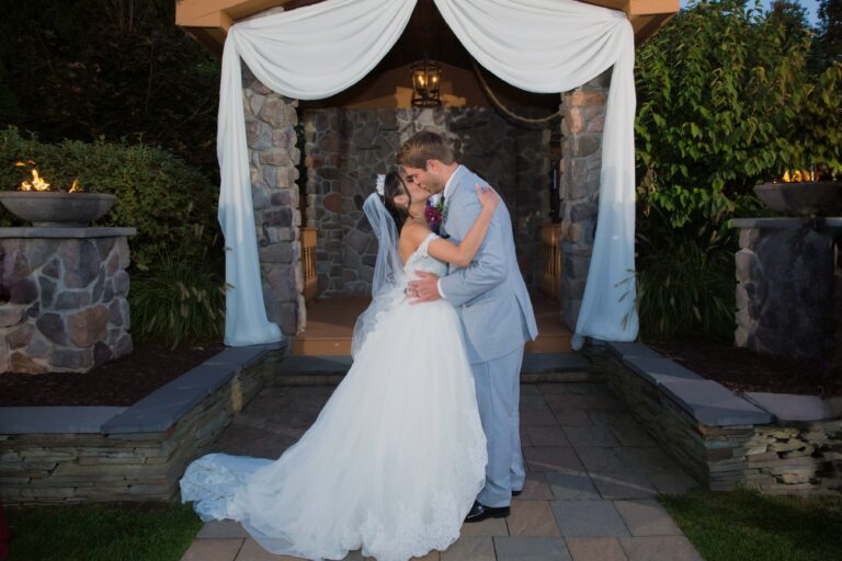 Bride and groom kiss in front of Lawnhaven gazebo