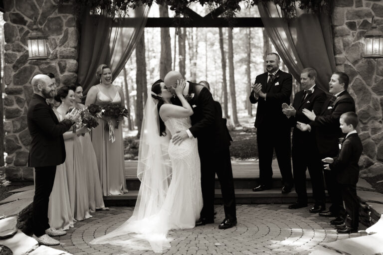 Bride and groom kiss at chapel altar