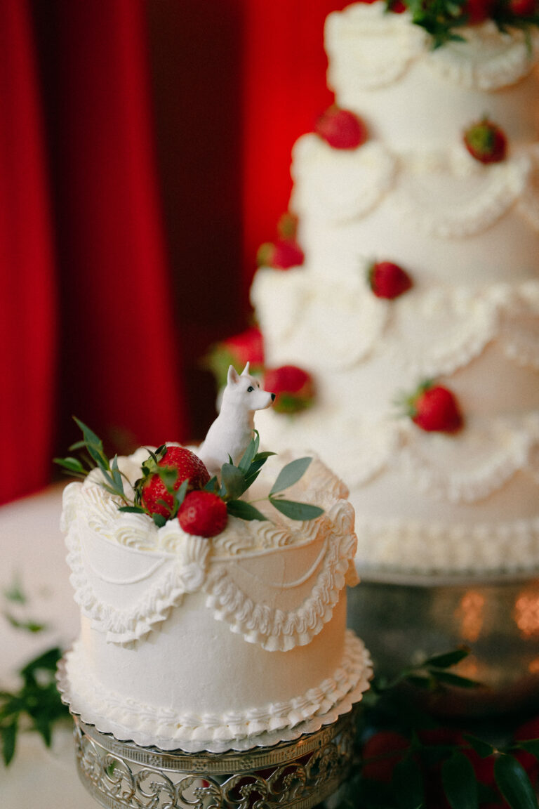 White dog cake topper atop miniature wedding cake