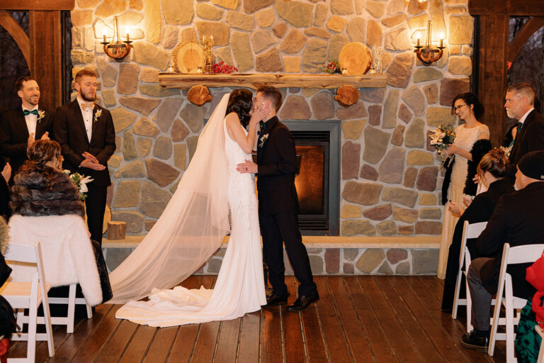 Bride and groom kiss beneath Woodsgate pavilion